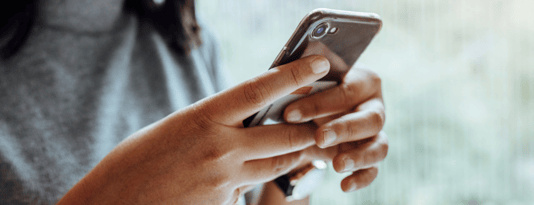 close up of a woman's hands holding a mobile phone