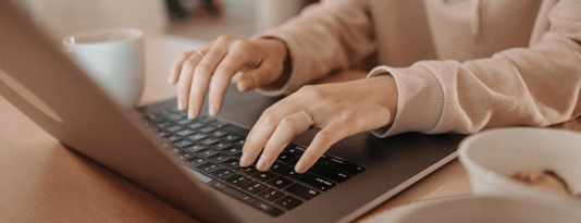 Woman types on macbook keyboard